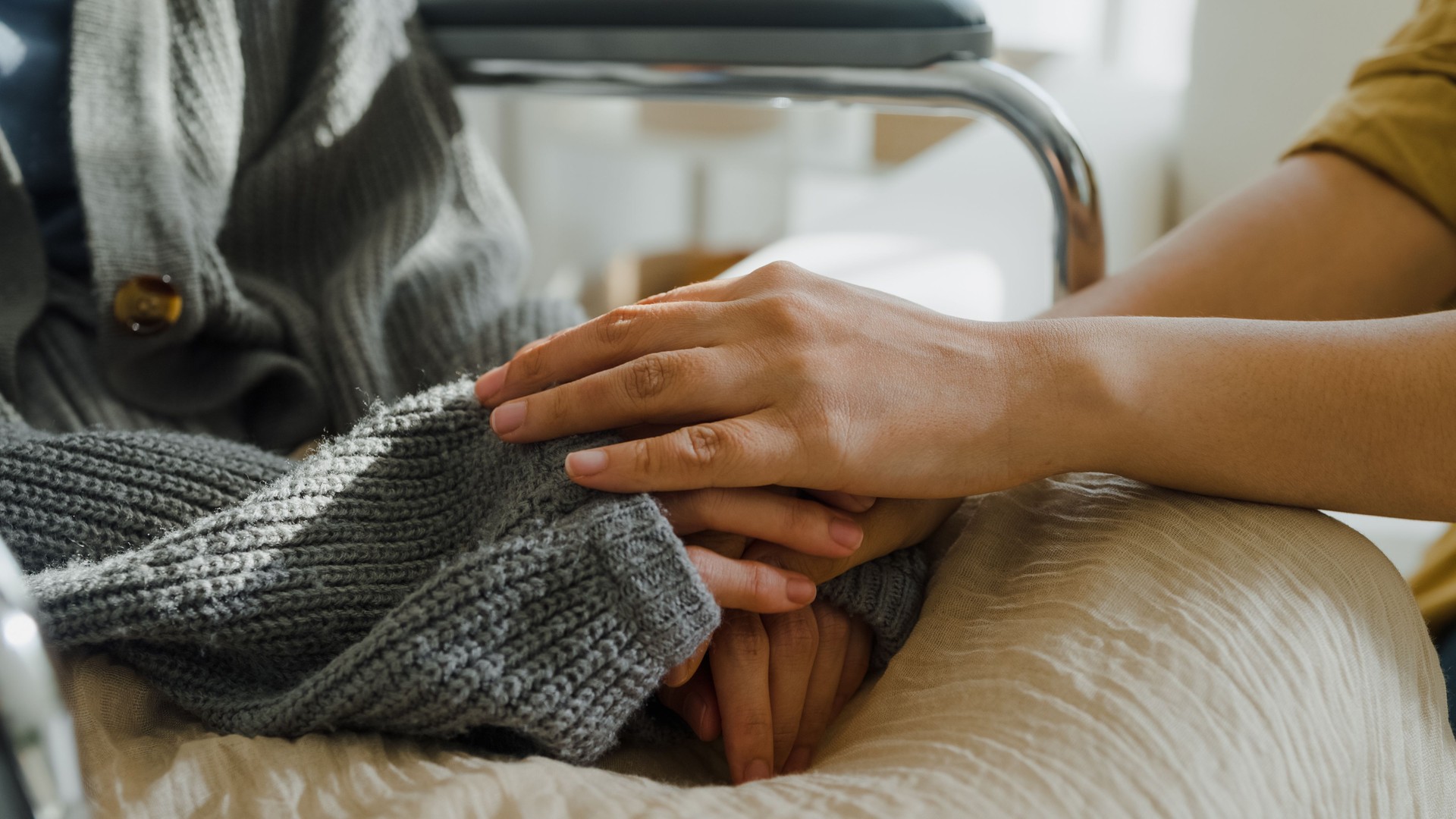 Closeup of young Asian people holding hands trust comfort help cancer patients talk crying stress relief in living room at home. Healthcare.